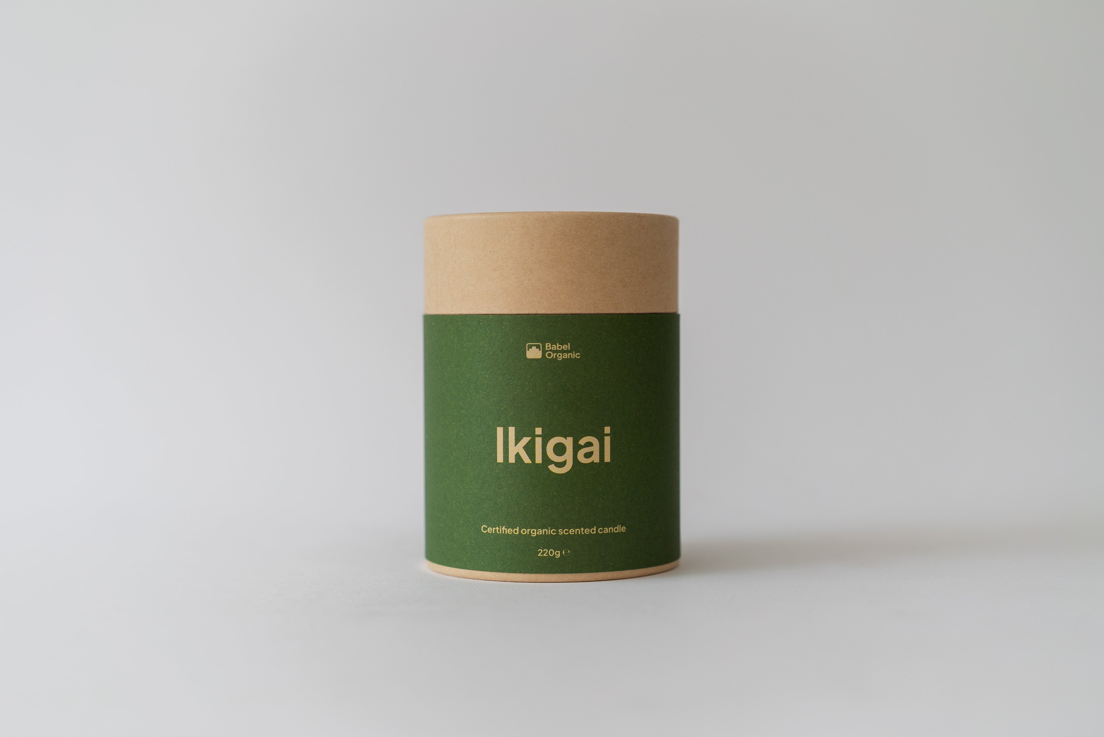 A cylindrical kraft paper canister with a dark green label reading 'Ikigai' in gold lettering, set against a plain light gray background.