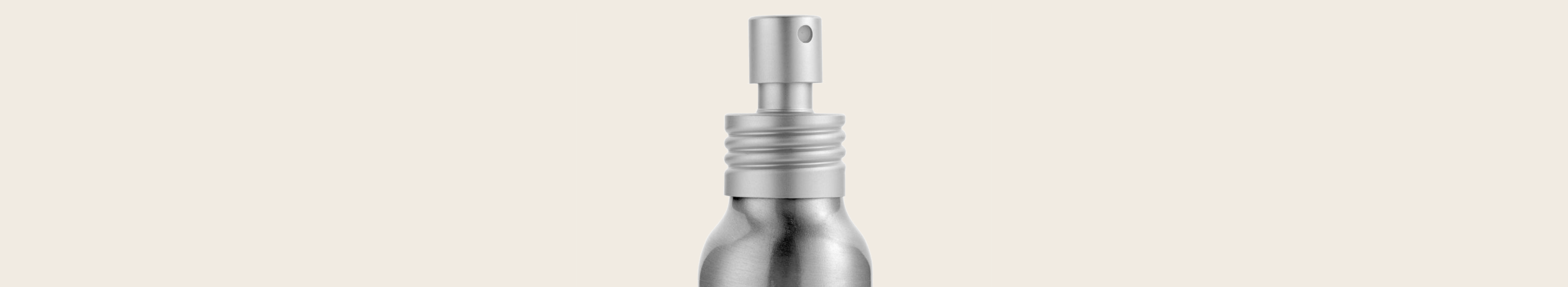 Silver spray bottle on a beige background