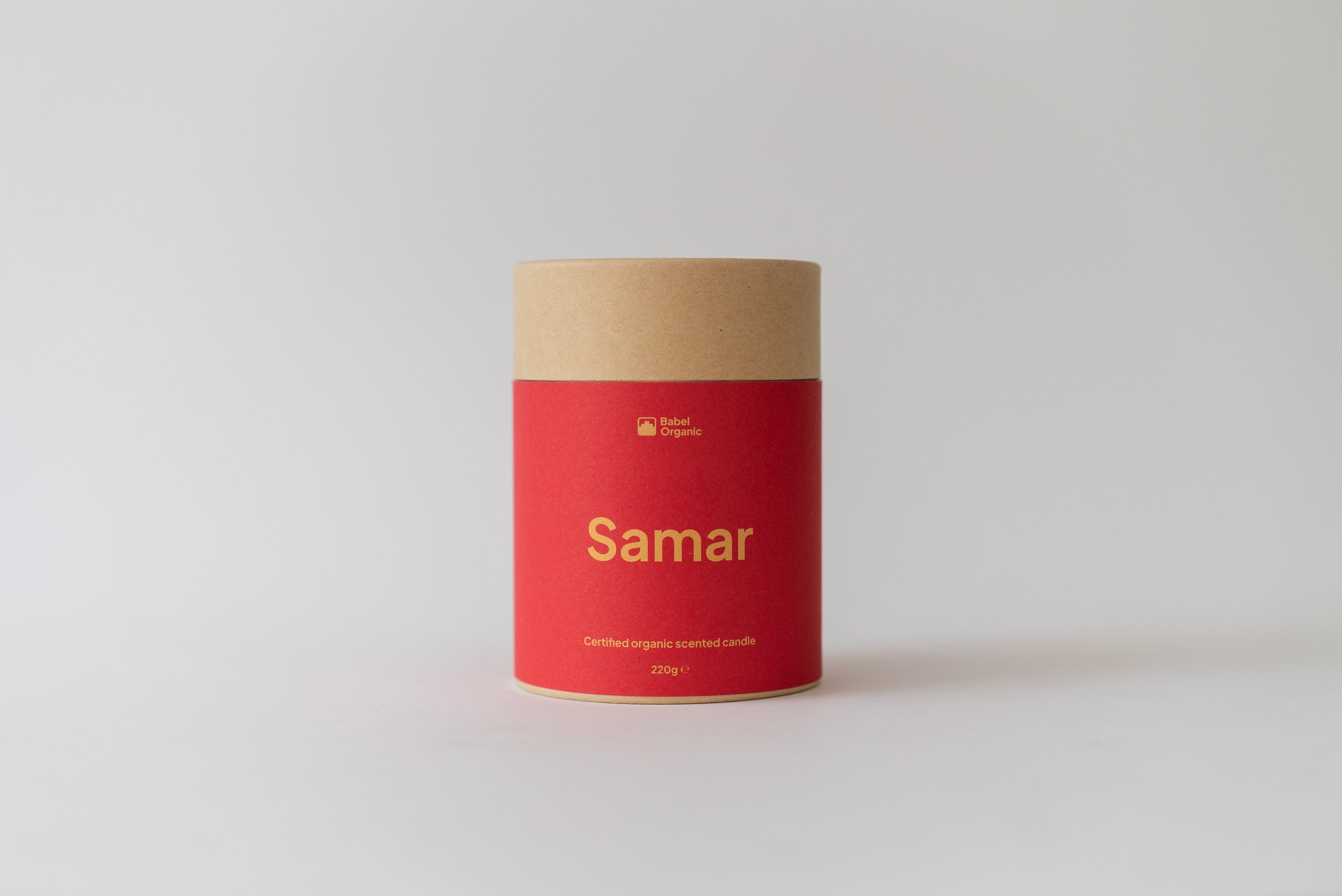A cylindrical cardboard container with a bright red label and natural kraft paper top, labeled 'Samar' in gold text, set against a clean light gray background.