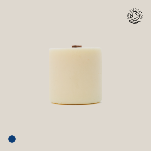 Beige cylindrical candle refill on a beige background with a visible Organic Certification logo